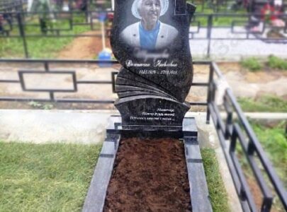 Памятник з кольоровою фотографією на кладовищі